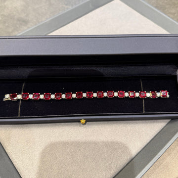 Ruby bracelet in a jewelry box on a textured surface