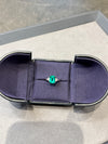 Emerald ring in a jewelry box on a light gray background