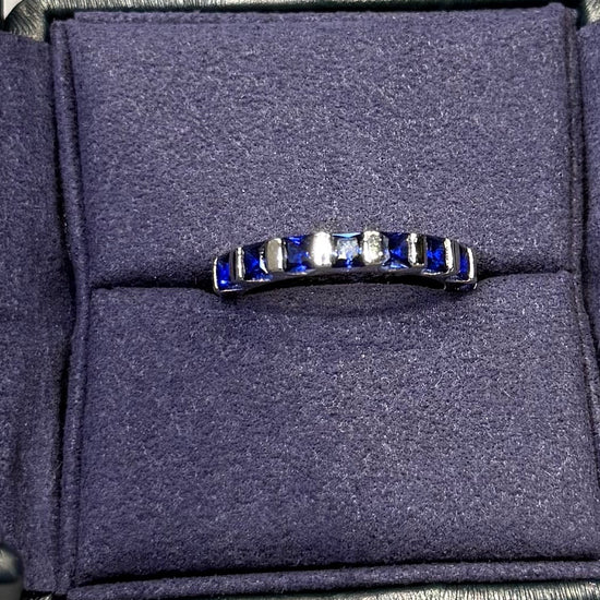 Navy sandal with a brand logo on a gray surface