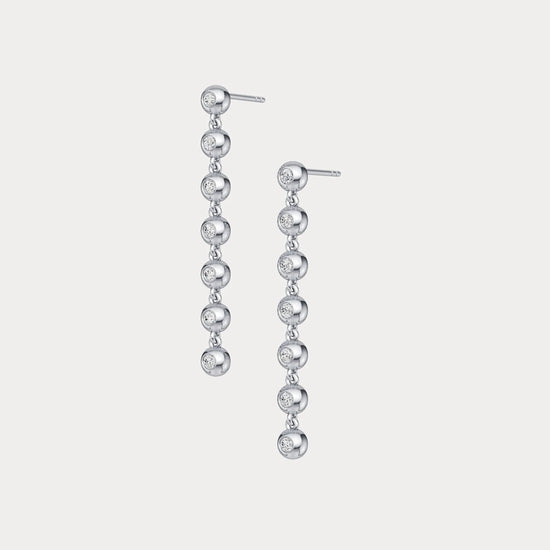 Pair of silver drop earrings on a light gray background