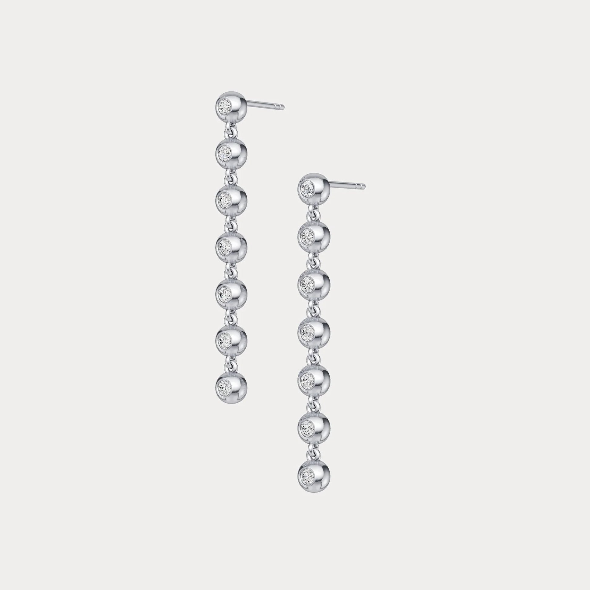 Pair of silver drop earrings on a light gray background