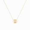 Gold necklace with a round pendant on a black background