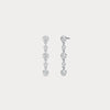 Pair of silver drop earrings with clear gemstones on a light gray background