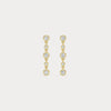 Gold earrings with clear stones on a light gray background