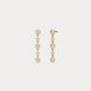 Gold earrings with clear stones on a light gray background