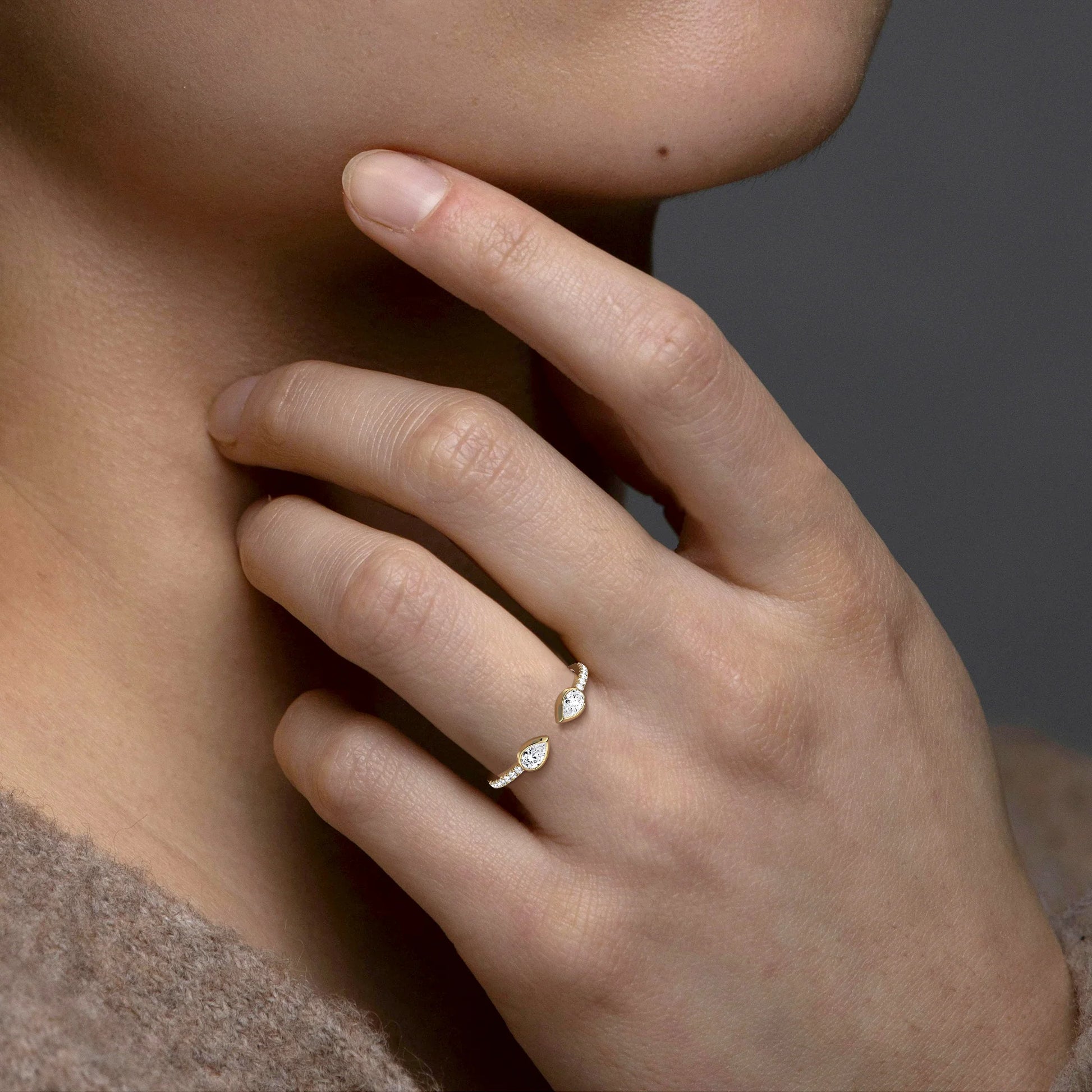 Close-up of a hand wearing a diamond ring with a blurred background