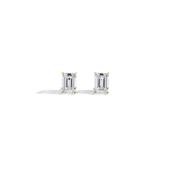 Pair of emerald-cut diamond earrings on a white background