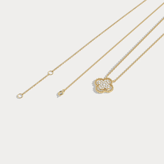 Gold necklace with a floral pendant on a light gray background