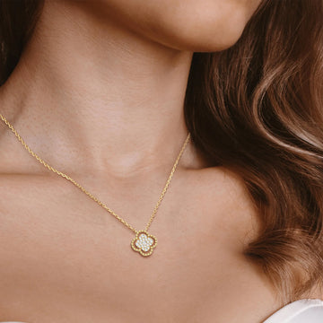 Gold necklace with a diamond pendant worn by a person