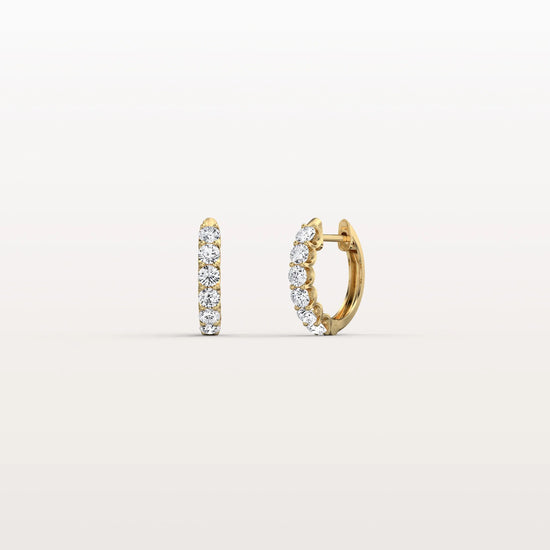 Gold hoop earrings with embedded stones on a light beige background