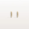 Gold hoop earrings with embedded diamonds on a light beige background