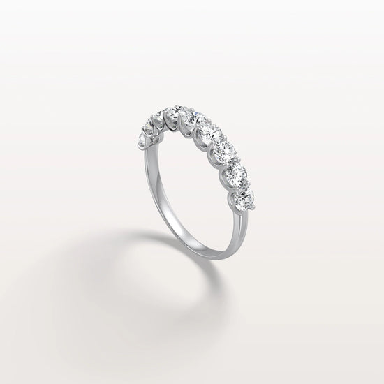 Silver ring with diamonds on a light gray background