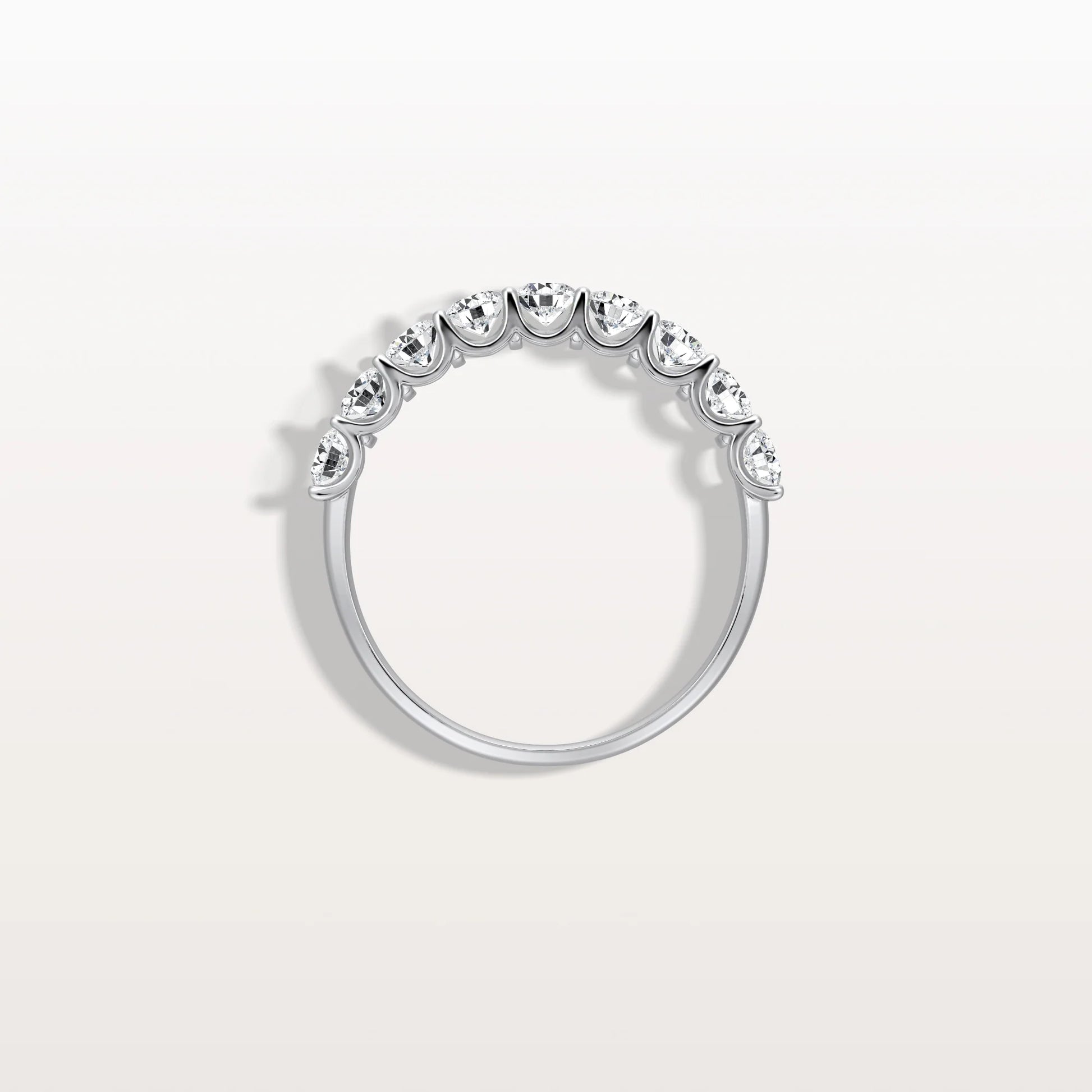 Silver ring with small diamonds on a light gray background