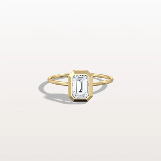 Gold ring with a rectangular diamond on a light gray background