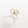 Gold ring with a rectangular diamond on a light gray background