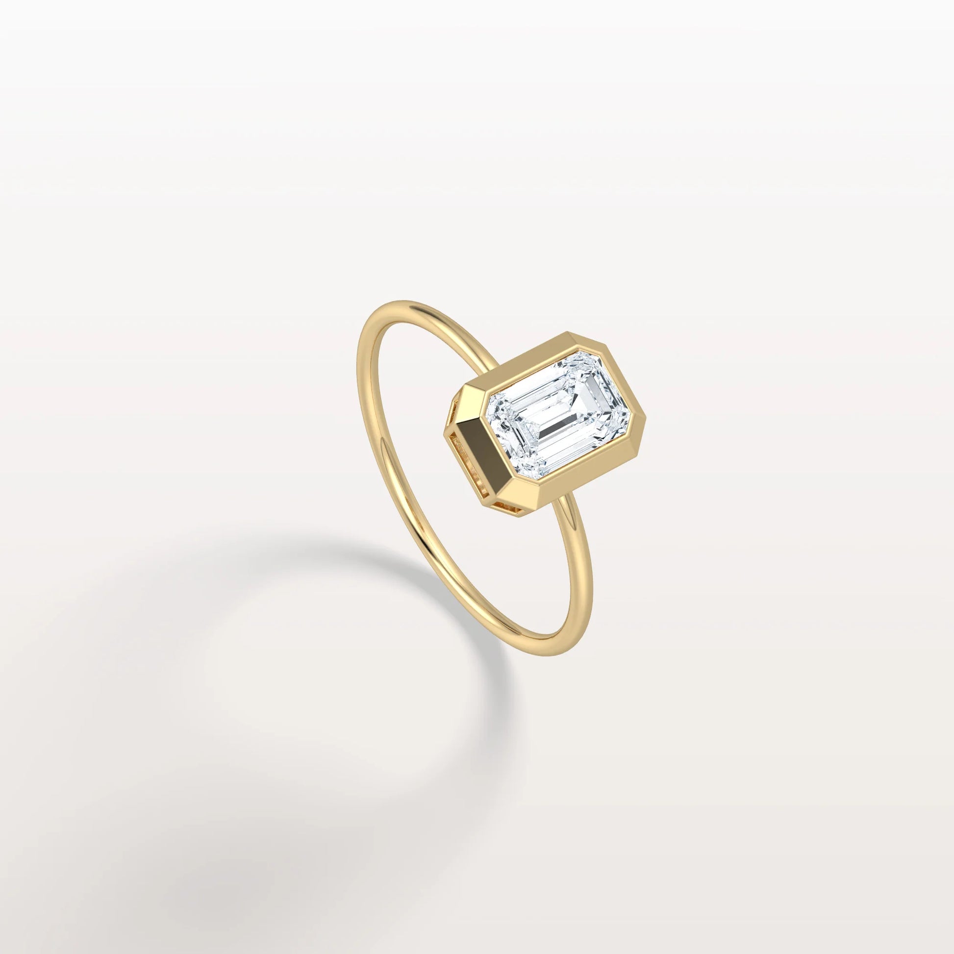 Gold ring with a rectangular diamond on a light gray background