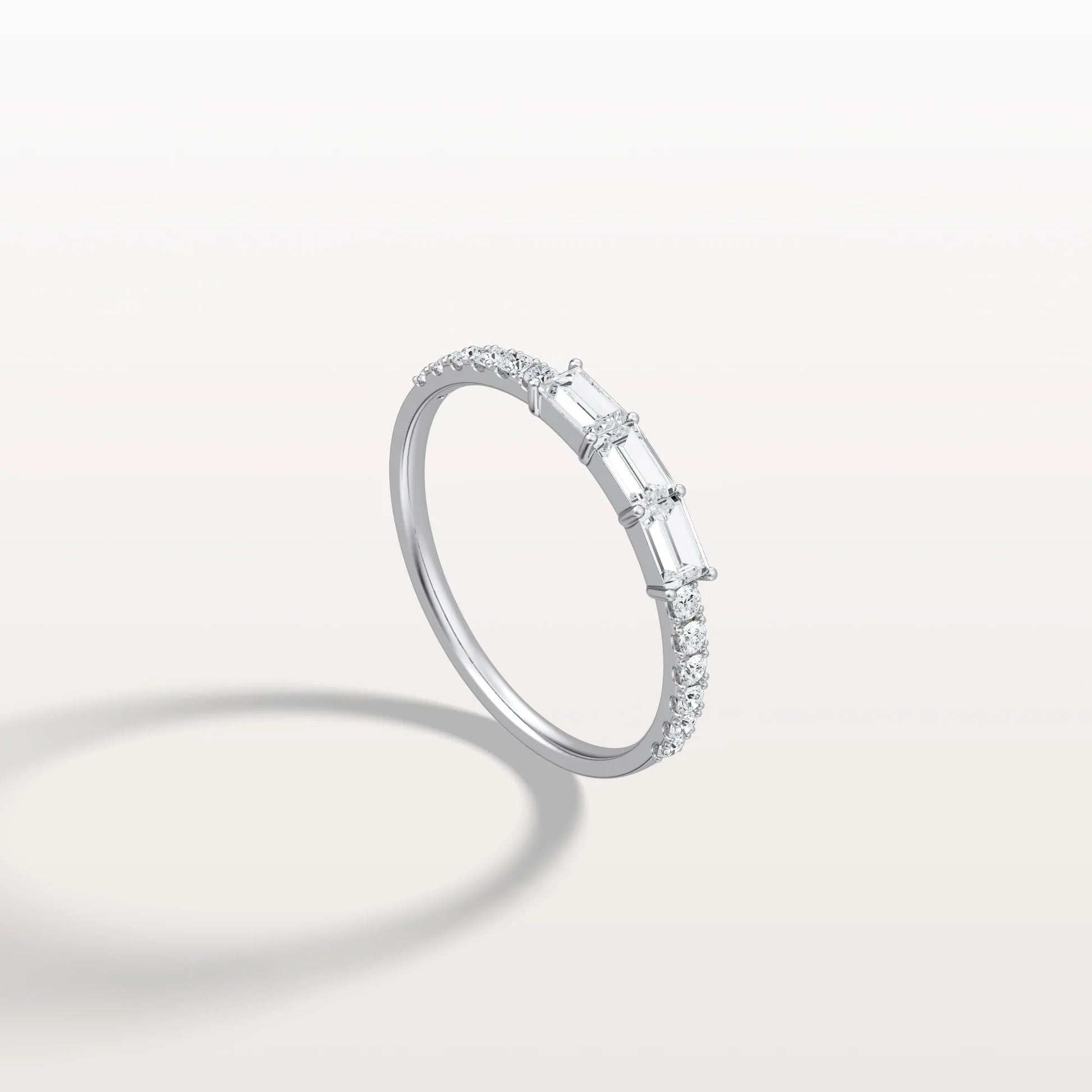 Diamond ring with baguette and round cut diamonds on a light gray background