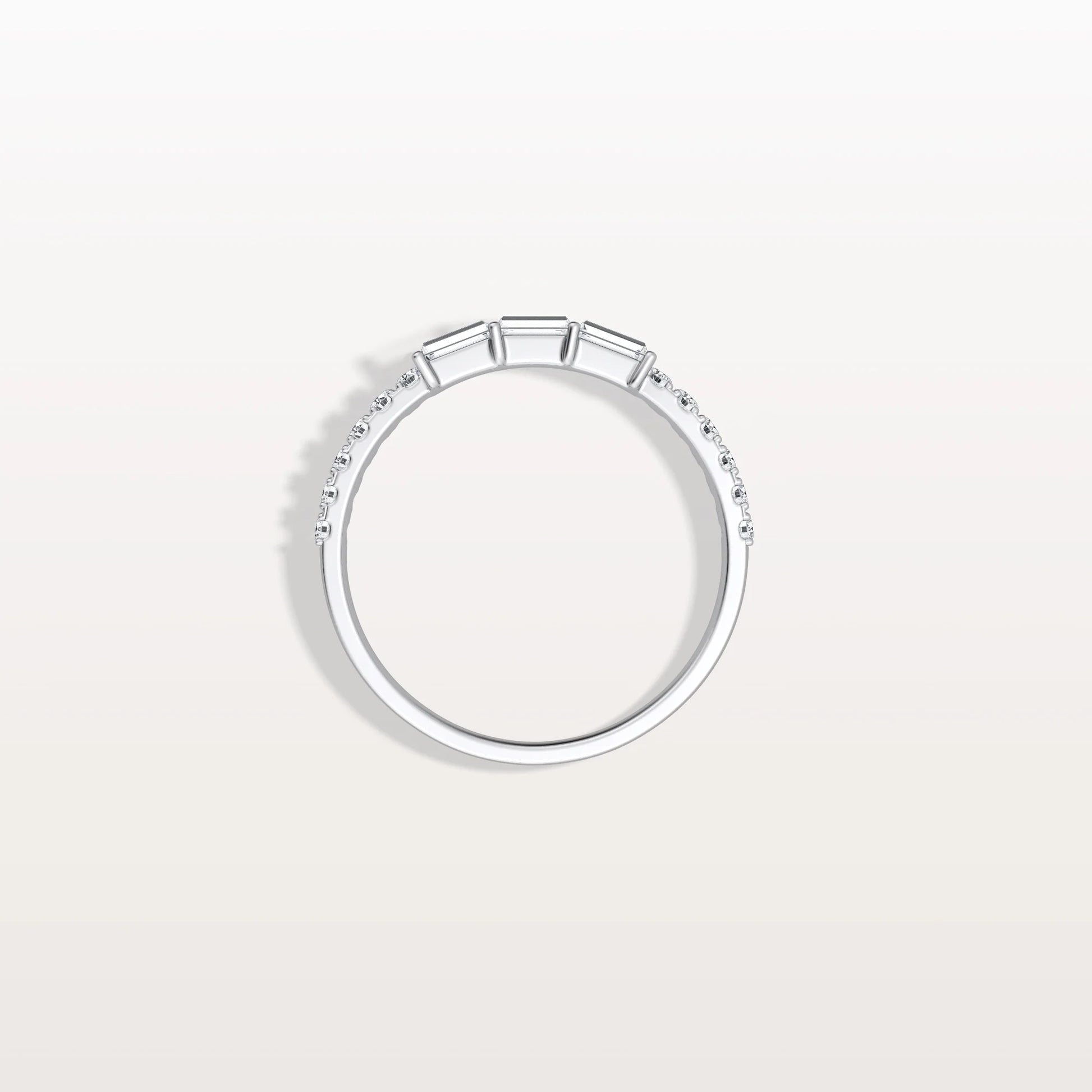 Silver ring with small diamonds on a light gray background