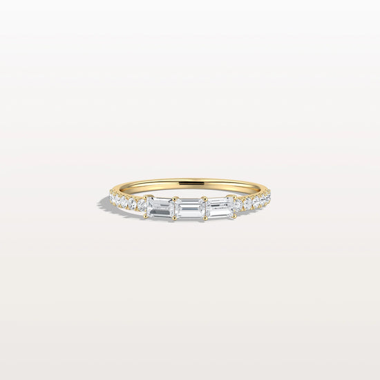 Gold ring with diamonds on a light gray background
