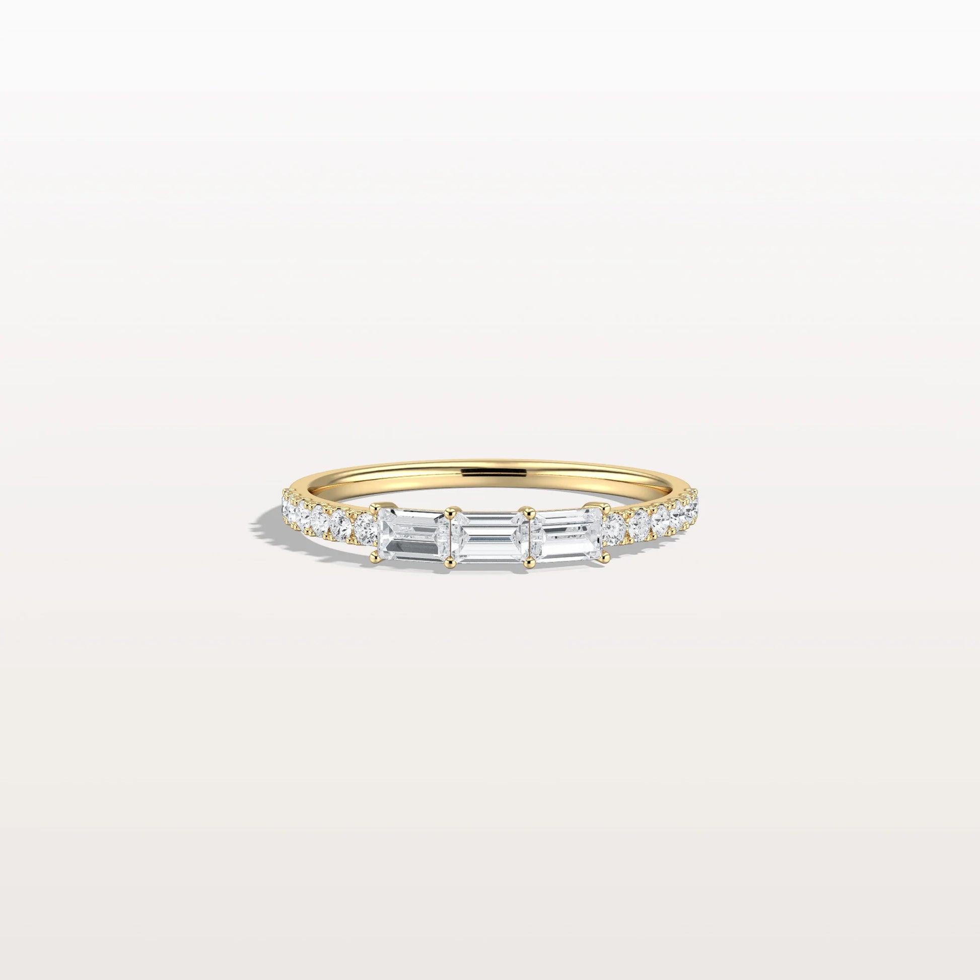 Gold ring with diamonds on a light gray background