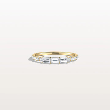 Gold ring with diamonds on a light gray background