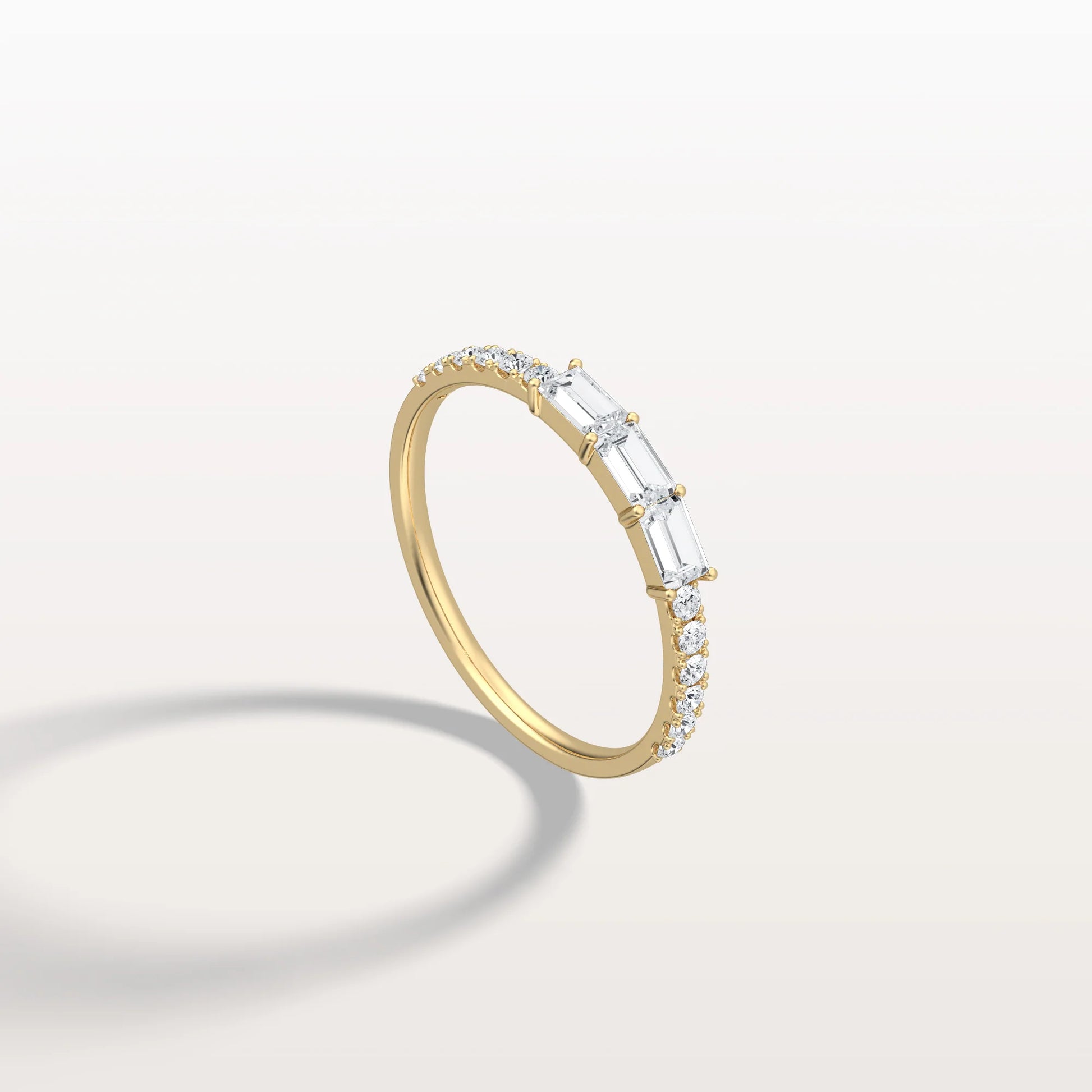 Gold ring with baguette diamonds on a light gray background