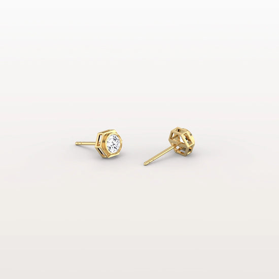 Gold stud earrings with clear gemstones on a light gray background
