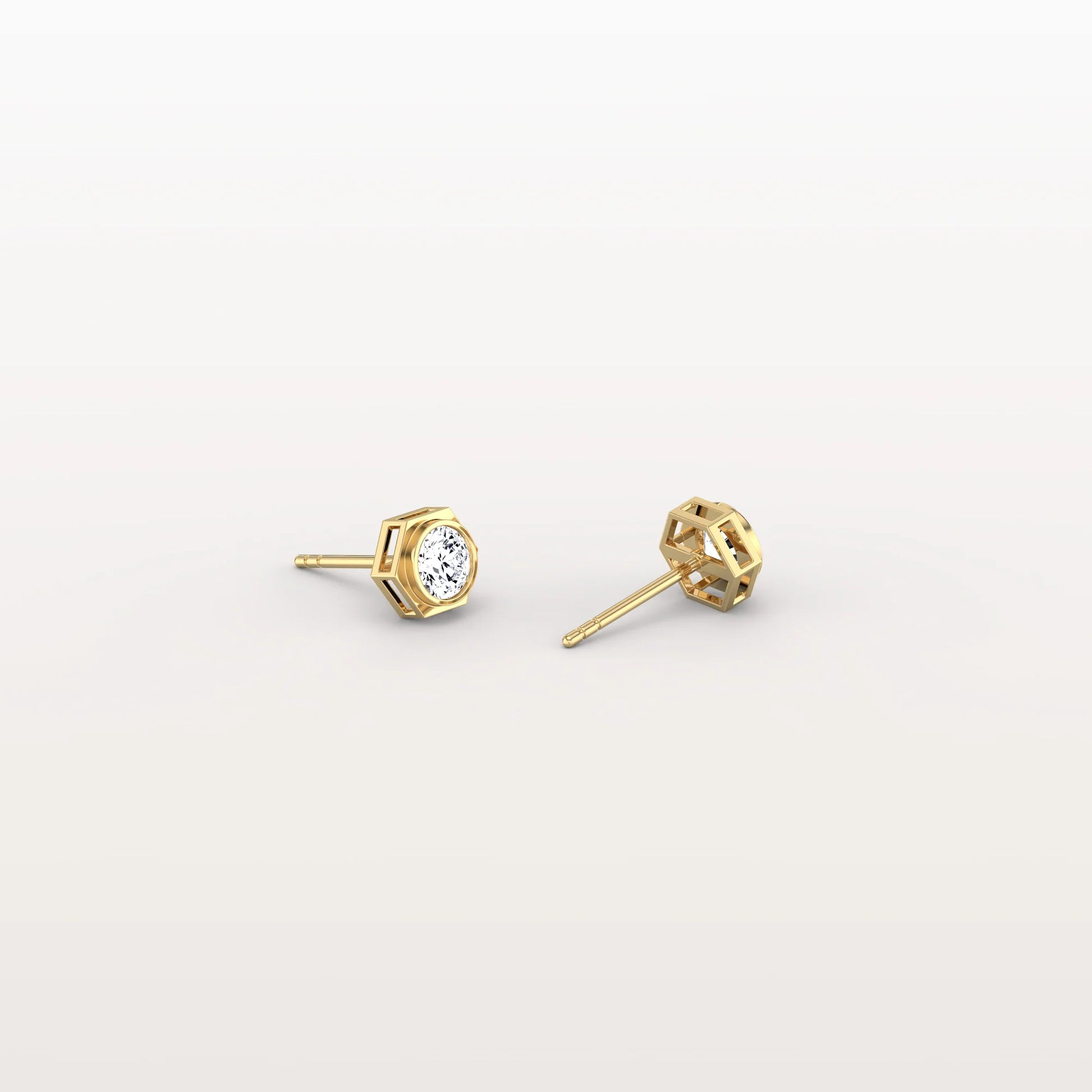 Gold stud earrings with clear gemstones on a light gray background