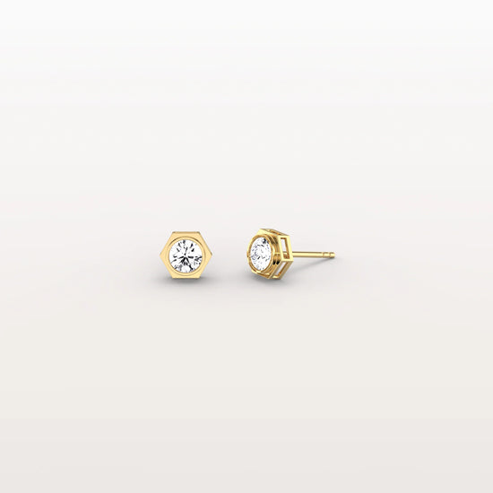 Gold stud earrings with gemstones on a light gray background