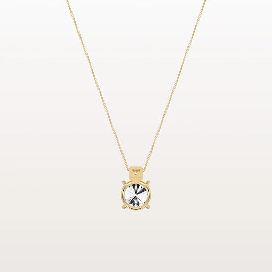 Gold necklace with a round pendant on a light gray background