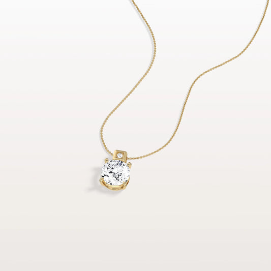 Gold necklace with a diamond pendant on a light gray background