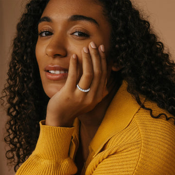 Woman wearing a mustard yellow sweater with a warm brown background
