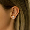 Close-up of an ear wearing a diamond stud earring with hair partially covering the frame.